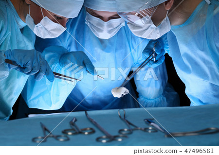 Group of surgeons in masks performing operation. Medicine, surgery and emergency help concepts 47496581