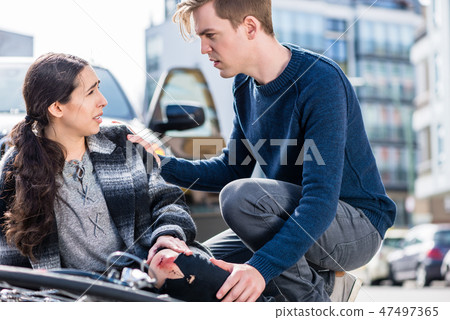Young man calling the emergency services after hitting a bicyclist Young man calling the emergency services after hitting a bicyclist 47497365