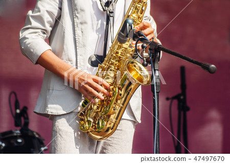 saxophonist playing at a jazz festival in a park 47497670