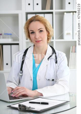 Doctor woman at work. Physician typing on laptop computer. Medicine, healthcare concept Doctor woman at work. Physician typing on laptop computer. Medicine, healthcare concept 47498219