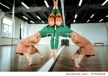 Red-haired professional young dance teacher looking involved Red-haired professional young dance teacher looking involved 47498889