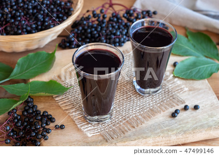 Two glasses of black elder syrup with elderberries 47499146