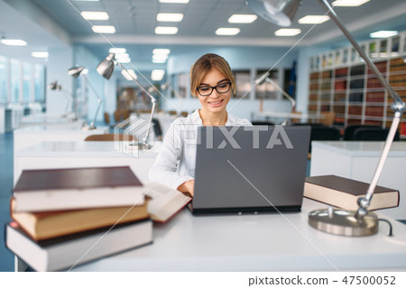 Female student studying at the laptop in library Female student studying at the laptop in library 47500052