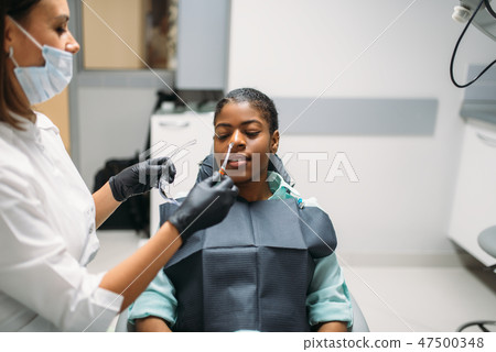 Dentist and female person, visit in dental clinic Dentist and female person, visit in dental clinic 47500348