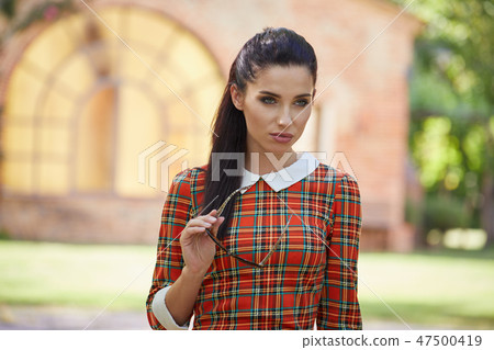 Smiling summer woman with sunglasses in italian garden Smiling summer woman with sunglasses in italian garden 47500419