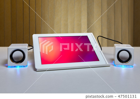 Two speakers are connected to a tablet computer. Two speakers are connected to a tablet computer. 47501131
