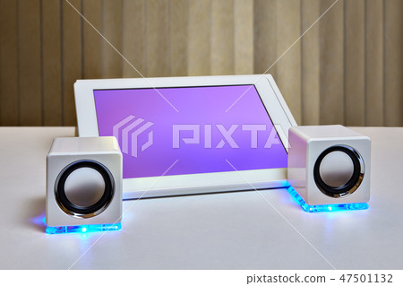 Tablet  placed near miniature speakers 47501132