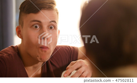 Closeup of young man looking surprised. Positive emotion 47502811