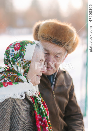 Senior people sits on the benck in the park. Happy elderly couple spend time outside in winter Senior people sits on the benck in the park. Happy elderly couple spend time outside in winter 47508366