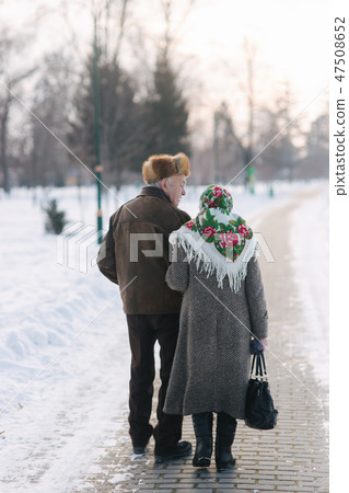 Back view of elderly couple walking in the park. Happy old people toghether though the years 47508652