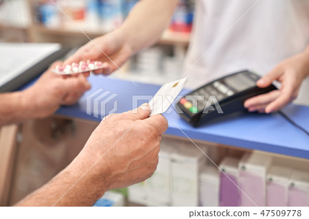 Man holding credit card after payment using terminal. Man holding credit card after payment using terminal. 47509778