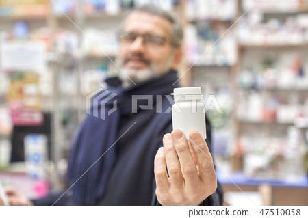 Close up of man holding white bottle mock. Close up of man holding white bottle mock. 47510058