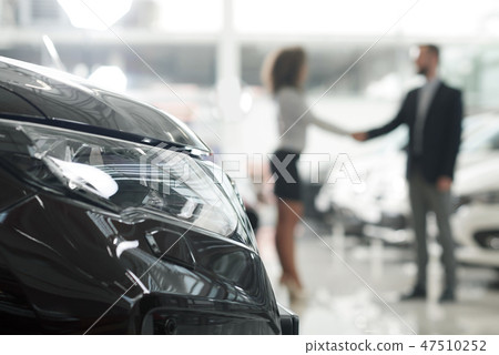 Car dealer and client shaking hands in showroom. Car dealer and client shaking hands in showroom. 47510252