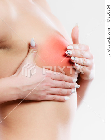 Woman examining her breasts 47510554