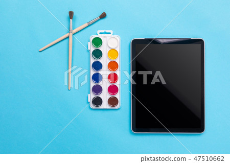 Watercolor paints and brush with tablet on blue background Watercolor paints and brush with tablet on blue background 47510662