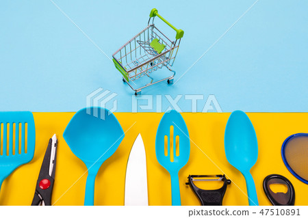 dummy shopping cart And kitchen utensils isolated on yellow-blue background 47510891