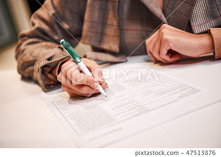 Businesswoman is fulfilling and signing contract with pen Businesswoman is fulfilling and signing contract with pen 47513876