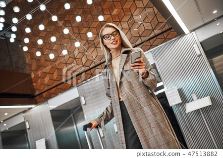 Full length portrait of a smiling successful businesswoman pulling suitcase Full length portrait of a smiling successful businesswoman pulling suitcase 47513882