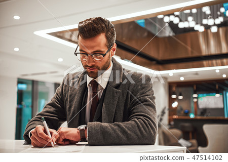 Man in Hotel check in at reception or front office, fulfills his profile 47514102