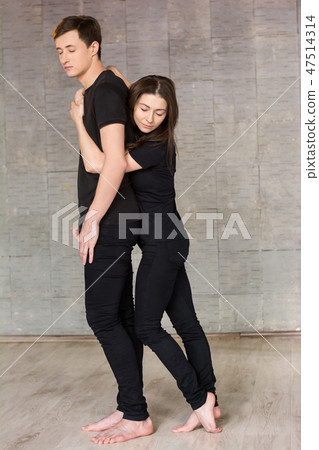 Pretty young dancer hugging her partner. 47514314
