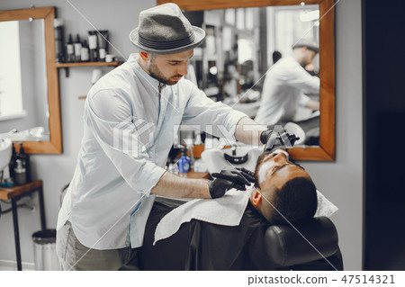 The man cuts his beard in the barbershop The man cuts his beard in the barbershop 47514321