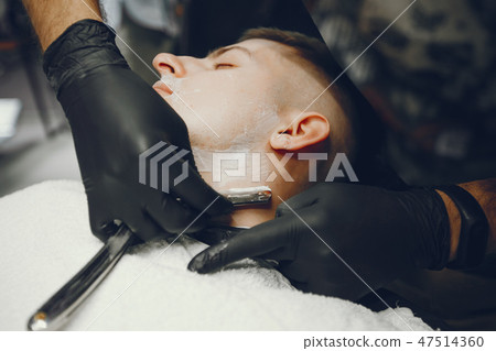 The man cuts his beard in the barbershop The man cuts his beard in the barbershop 47514360