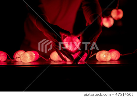 Man holds the led light lamp of heart shape Man holds the led light lamp of heart shape 47514505