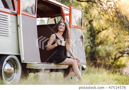 A young girl sitting in the boot of a car on a roadtrip through countryside. A young girl sitting in the boot of a car on a roadtrip through countryside. 47514576