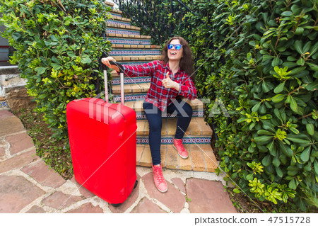 Travel, vacations and holidays concept - happy traveller woman sitting on stairs in sunny glasses 47515728