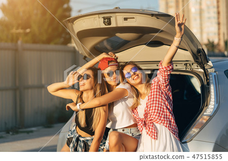 Three young woman posing for the camera the car park. Three young woman posing for the camera the car park. 47515855