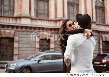 A young, sexy couple of lovers pose for a camera on the streets A young, sexy couple of lovers pose for a camera on the streets 47515975