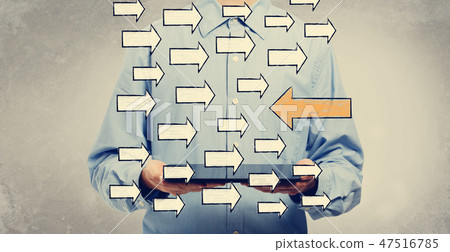 Arrow going in a opposite direction with man holding a tablet Arrow going in a opposite direction with man holding a tablet 47516785