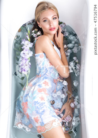Beautiful girl in a summer dress in the bathroom with flowers. Beauty face. Beautiful girl in a summer dress in the bathroom with flowers. Beauty face. 47516794