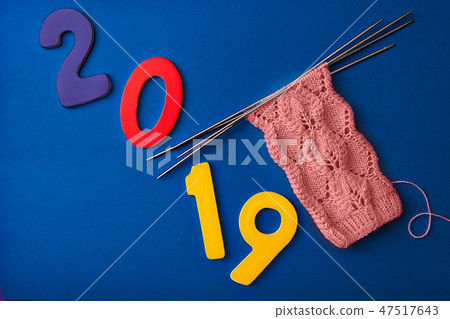 numbers 2019 and pink socks made of wool, knitted with an openwork pattern on four knitting needles 47517643