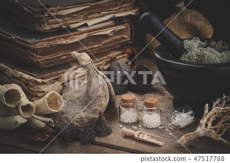 Bottles of homeopathic globules, mortar, old books Bottles of homeopathic globules, mortar, old books 47517788