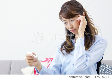 A woman watching a thermometer 47518227