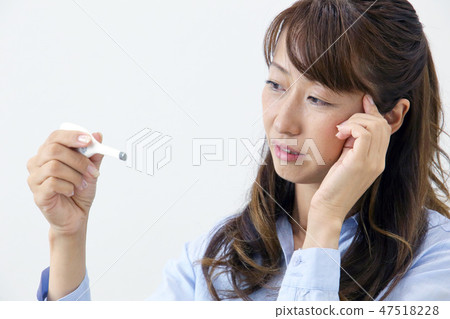 A woman watching a thermometer A woman watching a thermometer 47518228