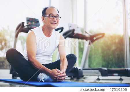 Senior man do body stretching in fitness center. Senior man do body stretching in fitness center. 47519396