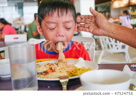 Boy puking on plate after having lunch meal Boy puking on plate after having lunch meal 47524758