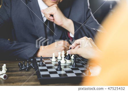 hand of businessman moving chess figure in competition board gam 47525432