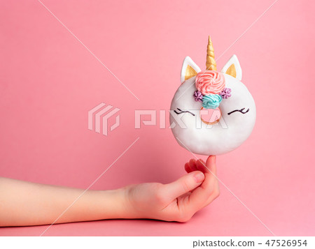 Unicorn donut on forefinger, copy space 47526954