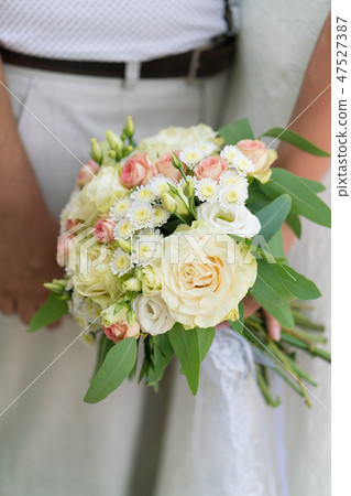 the bride is holding a pink and beige wedding bouquet of fresh flowers and eucalyptus the bride is holding a pink and beige wedding bouquet of fresh flowers and eucalyptus 47527387