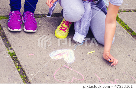 Children draw the heart on the asphalt. Children draw the heart on the asphalt. 47533161