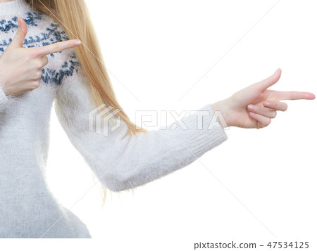 Teenage blonde woman pointing at copyspace Teenage blonde woman pointing at copyspace 47534125