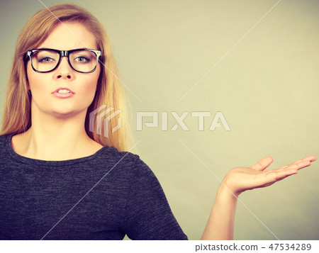 Nerdy woman in eyeglasses being confused 47534289