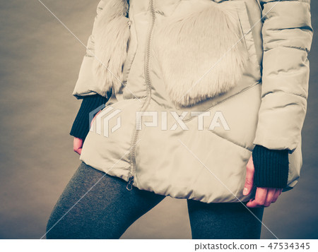 Woman wearing winter warm furry jacket 47534345