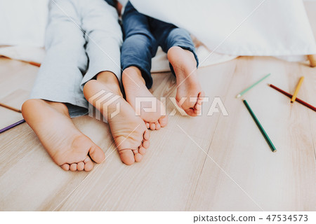 Close up children legs under white blanket Close up children legs under white blanket 47534573