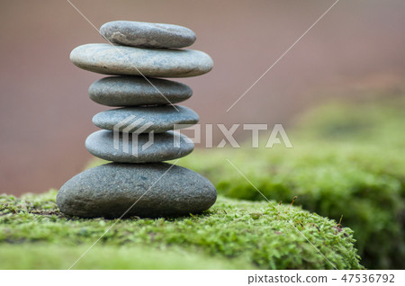 Closeup of stone balance on moss in the forest 47536792