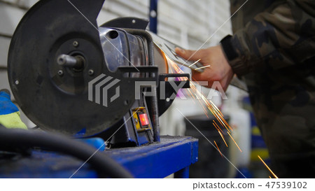 Car service. A worker grind the number plates. Fire flakes Car service. A worker grind the number plates. Fire flakes 47539102