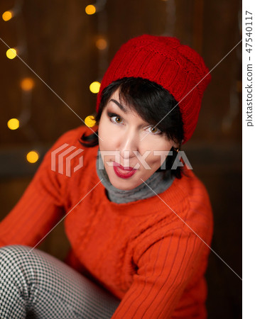 Beautiful woman posing on dark wooden background Beautiful woman posing on dark wooden background 47540117